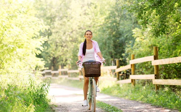 Bicicleta de montar mujer con cesta en el parque de verano — Foto de Stock