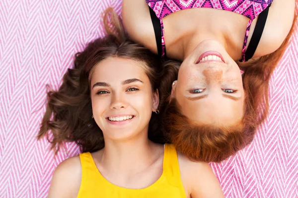 Chicas adolescentes sonrientes tumbadas en una manta de picnic —  Fotos de Stock