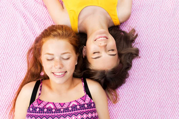 Uśmiechający się nastoletnich dziewcząt, leżącego na koc piknikowy — Zdjęcie stockowe