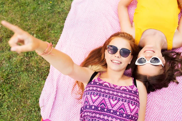 Teenage girls in sunglasses on picnic blanket — Stock Photo, Image
