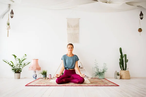 Kobieta medytująca w pozycji lotosu w studiu jogi — Zdjęcie stockowe