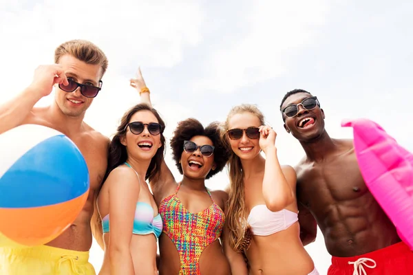 Amigos felices en gafas de sol en la playa de verano —  Fotos de Stock