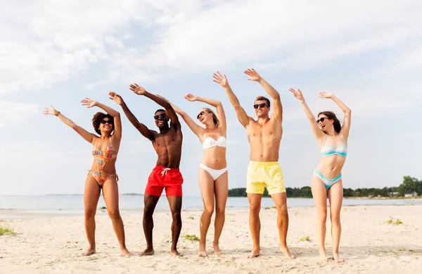 Amigos felices divirtiéndose en la playa de verano — Foto de Stock