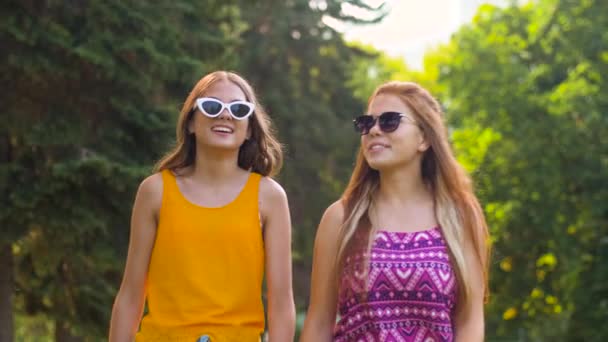 Tienermeisjes of vrienden wandelen in de zomer park — Stockvideo