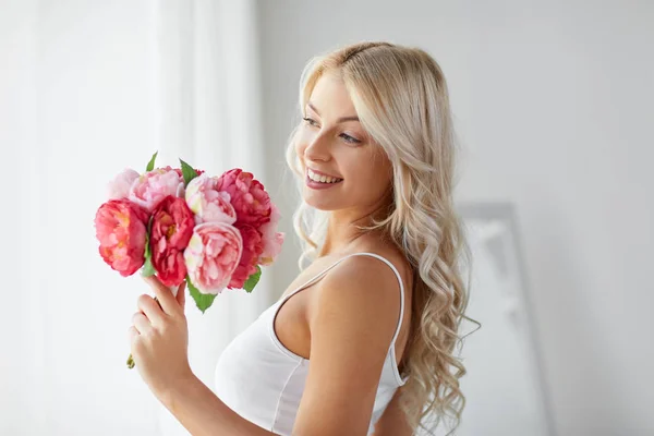 Mulher em roupa interior com um monte de flores na janela — Fotografia de Stock