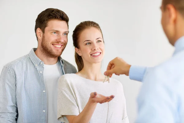 Realtor giving keys from new home to happy couple — Stock Photo, Image