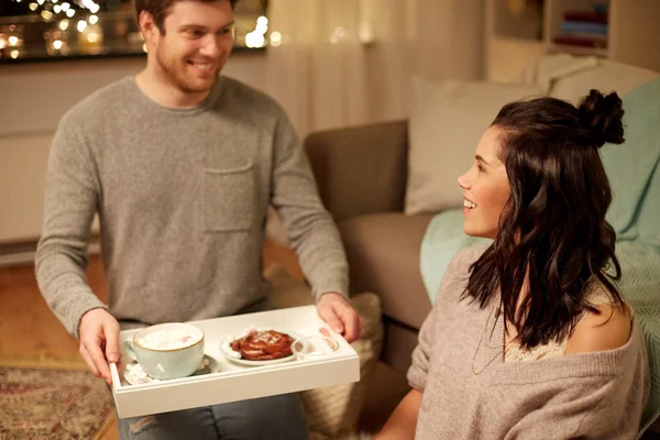 Casal feliz com comida na bandeja em casa — Fotografia de Stock