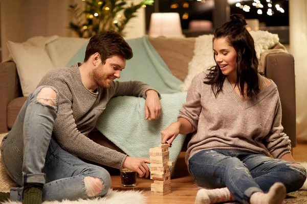 Feliz pareja jugando bloque-apilamiento juego en casa — Foto de Stock