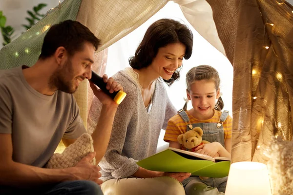 Heureux livre de lecture de famille dans la tente des enfants à la maison — Photo