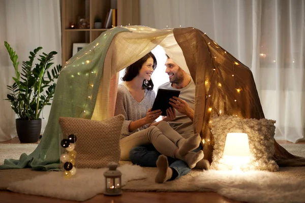 Coppia felice con tablet pc in tenda per bambini a casa — Foto Stock