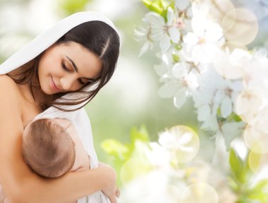mother breast feeding baby over cherry blossoms clipart