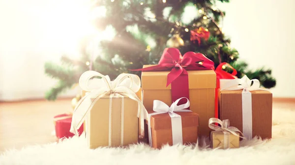 Geschenkdozen op schapenvacht bij kerstboom — Stockfoto