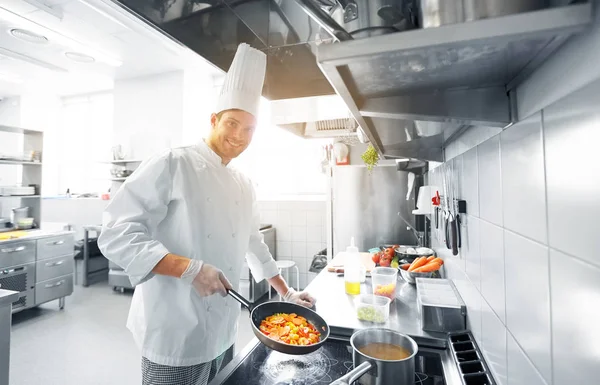 Happy male chef cooking food at restaurant kitchen — Stock Photo, Image