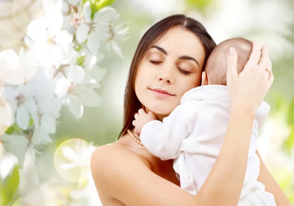 Мать с ребенком на фоне цветения вишни — стоковое фото