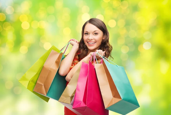 Junge lächelnde Frau mit Einkaufstüten über Lichtern — Stockfoto