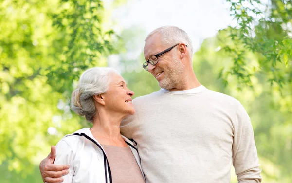 Happy senior couple over green natural background — Stock Photo, Image