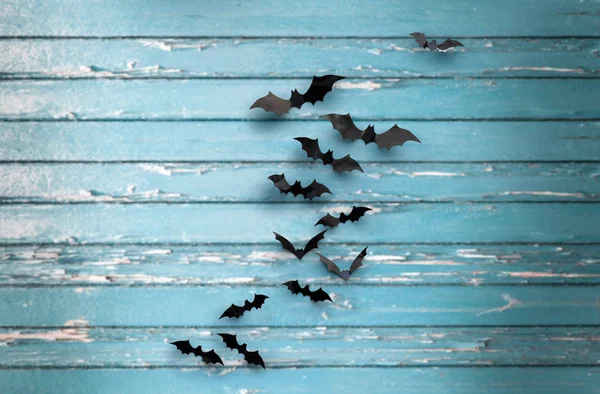 Black bats over blue shabby boards background — Stock Photo, Image