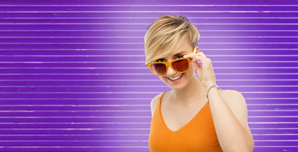 Женщина в солнечных очках на ультрафиолетовом фоне — стоковое фото