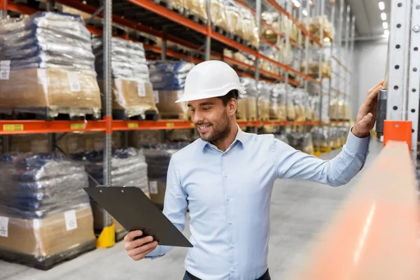 Бизнесмен в шлеме с планшетом на складе — стоковое фото