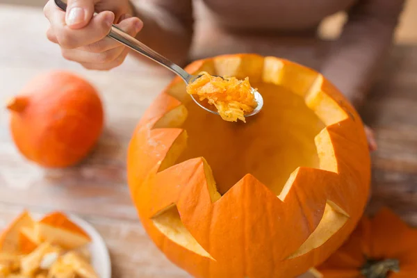 Nahaufnahme einer Frau, die Halloween-Kürbis schnitzt — Stockfoto