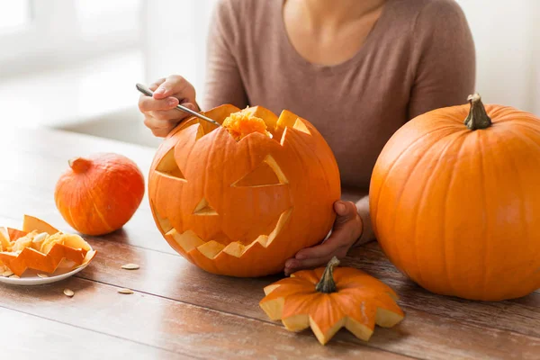Zbliżenie kobieta carvingowa dynia halloween — Zdjęcie stockowe