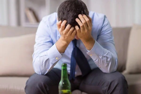 Alcoólico masculino com garrafa de cerveja em casa — Fotografia de Stock