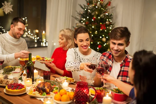 Mutlu arkadaşlar Noel partisinde kırmızı şarap içerler. — Stok fotoğraf