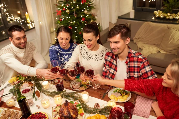 Друзья празднуют Рождество и пьют вино — стоковое фото