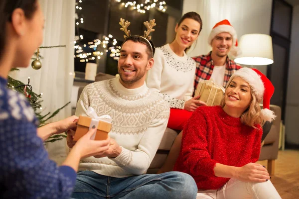 Amigos celebrando o Natal e dando presentes — Fotografia de Stock