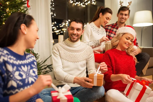 Amigos comemorando o Natal e abrindo presentes — Fotografia de Stock