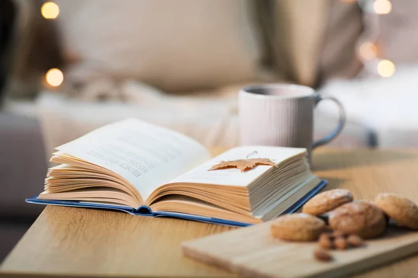 Livro com folha de outono, biscoitos e chá na mesa — Fotografia de Stock