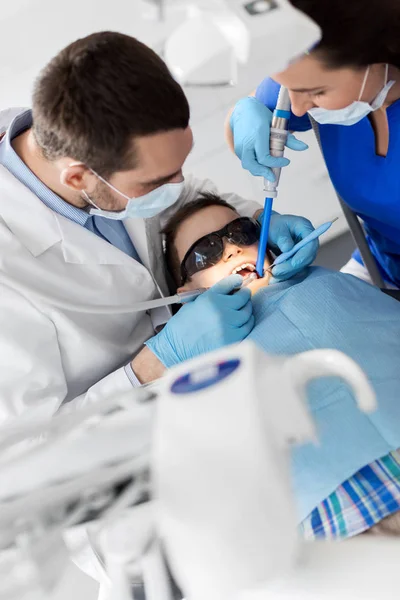 Стоматолог, лечащий детские зубы в стоматологической клинике — стоковое фото