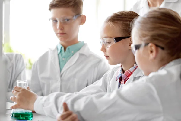 Bambini con provette che studiano chimica a scuola — Foto Stock