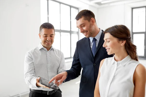 Makelaar tablet pc tonen aan klanten op kantoor — Stockfoto