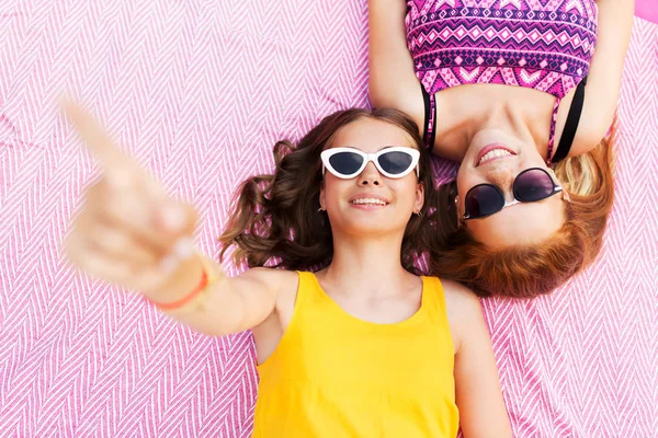 Piknik battaniyesi üzerinde güneş gözlüklü genç kızlar — Stok fotoğraf