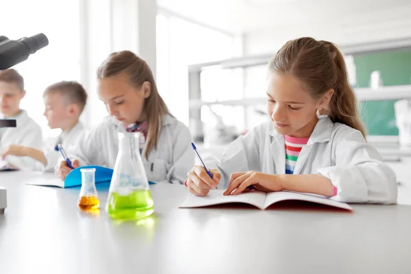 Niños estudiando química en el laboratorio de la escuela Imagen De Stock