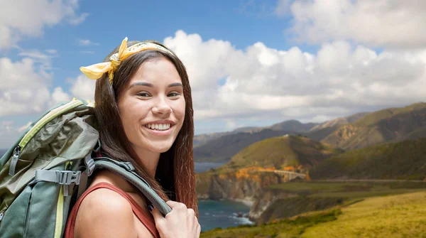 Счастливая женщина с рюкзаком во время прогулки на большом побережье — стоковое фото