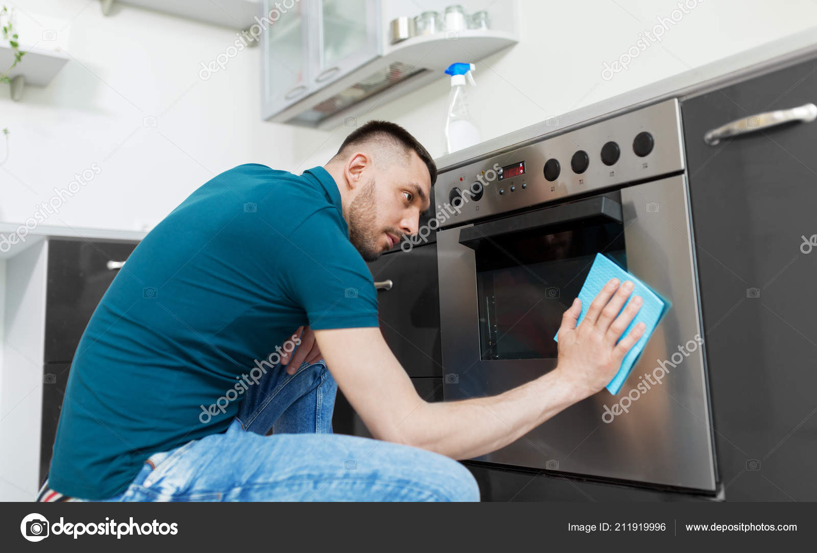 Homme avec chiffon nettoyage four porte à la maison cuisine image