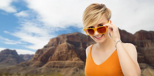 Portrait de jeune femme souriante en lunettes de soleil — Photo