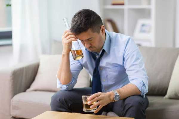 Alcoólico com garrafa bebendo uísque em casa — Fotografia de Stock