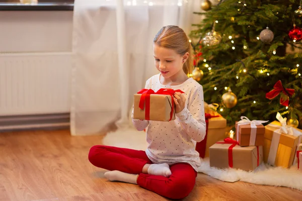 Χαμογελαστό κορίτσι με τα χριστουγεννιάτικα δώρα στο σπίτι — Φωτογραφία Αρχείου