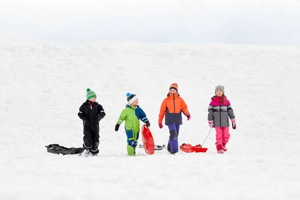 Mutlu küçük kışın sledging kızaklarımız ile çocukların — Stok fotoğraf