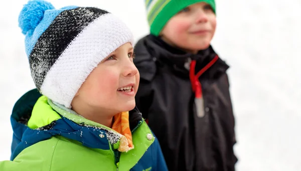 Закрыть глаза на маленьких мальчиков в зимней одежде на улице — стоковое фото