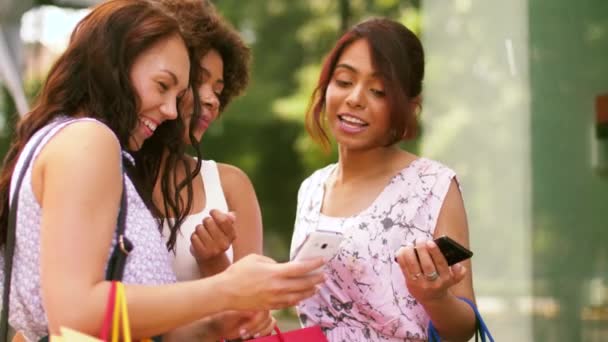 Mujeres con smartphones y bolsas de compras en la ciudad — Vídeo de stock