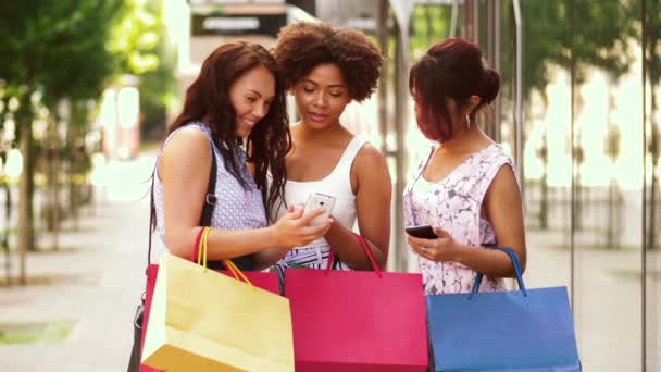 Mujeres con smartphones y bolsas de compras en la ciudad — Vídeos de Stock