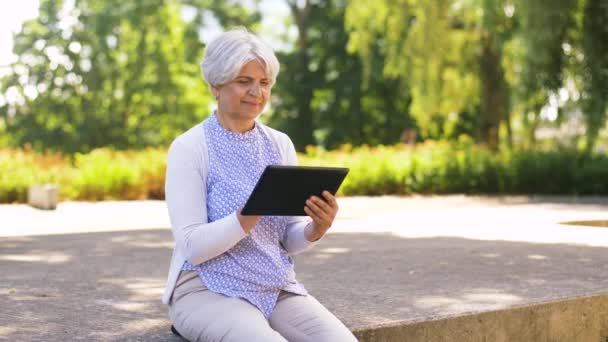 Mujer mayor con tableta PC en el parque de verano — Vídeo de stock