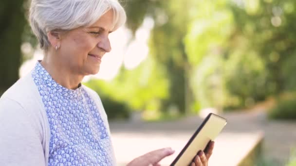 Donna anziana con tablet pc al parco estivo — Video Stock