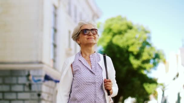 Happy senior woman walking along summer city — Stock Video