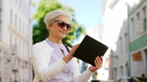 Senior woman with tablet pc on city street — Stock Video