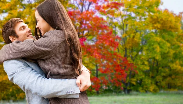 Casal sorridente abraçando no parque de outono — Fotografia de Stock